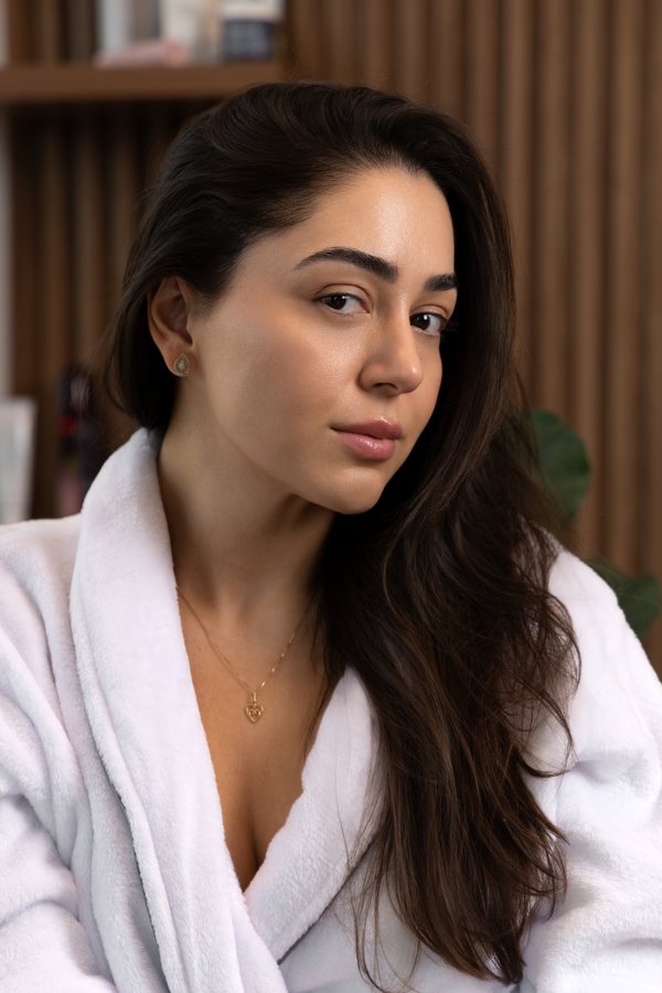 Mulher de roupão branco com a pele do rosto em evidência