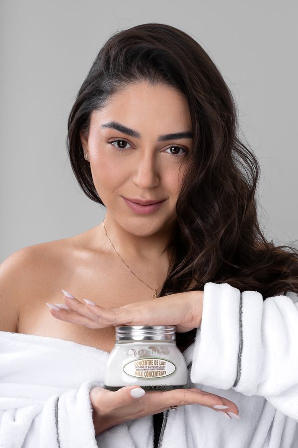 Mulher segurando um pote de cosmético com o rótulo à mostra